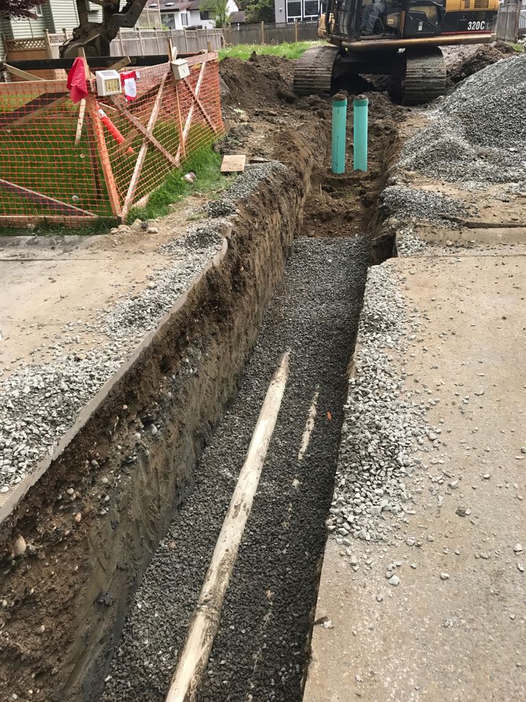 Maple Excavating CAT excavator and drainage trench on a Surrey job site